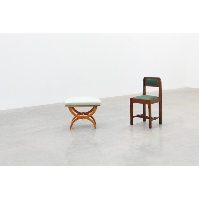 A refined French Empire‑style stool featuring an elegant X‑frame in cherrywood and a softly upholstered seat in pale...