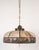 1910s pendant light with a slag glass shade with a repetitive windmill motif paired with an antique brass fitter and pull...