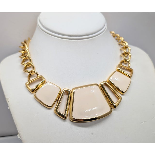 Circa late 1980s goldtone three ivory enamel plaques in the front on a chain with fold over clasp necklace. Marked...