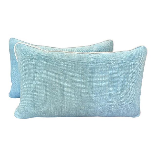Fresh and versatile pair of custom lumbar pillows upholstered in a soft aqua textured performance fabric with crisp white...