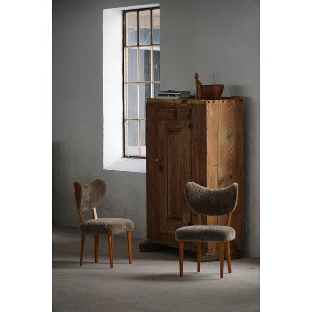 A refined dining / desk chair from the mid-20th century, distinguished by its elegant wood frames and softly sculpted...
