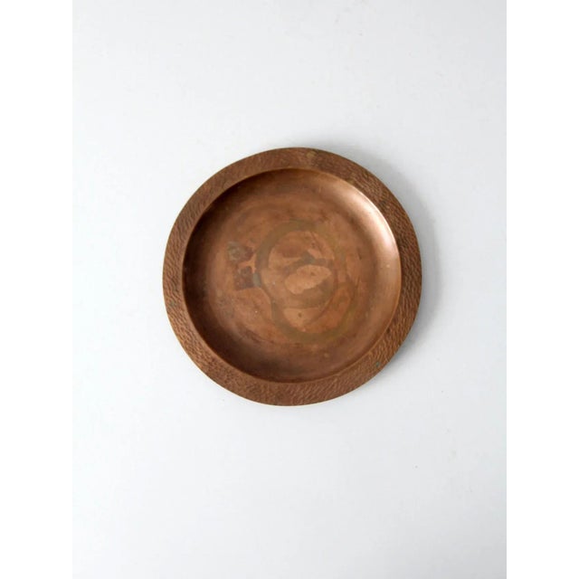 An antique early 20th-century Arts & Crafts copper plate with a shallow hand-formed profile and broad hammered rim. The...