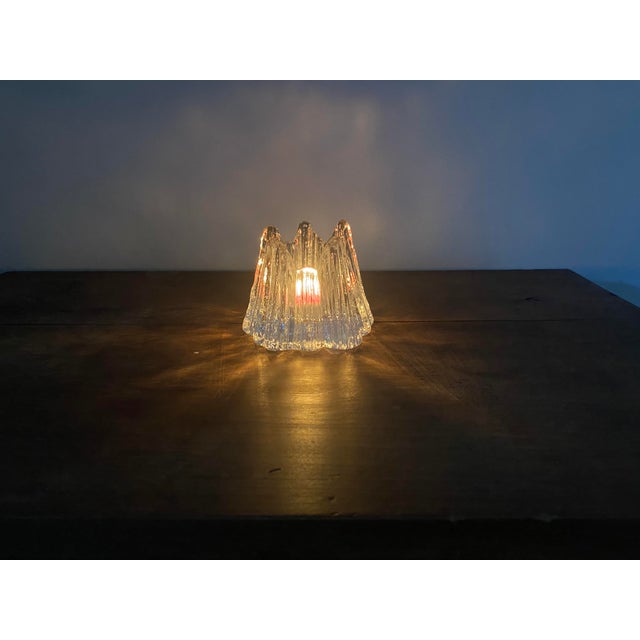 Designed by Swedish glass artist Rune Strand for Nybro Glasbruk, this vintage Volcano votive candle holder is a...