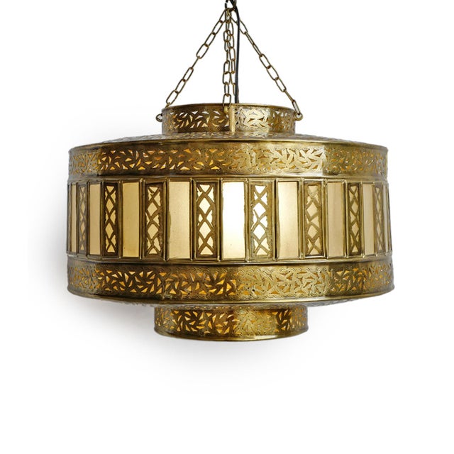 Hand crafted Indian pendant light featuring an intricately pierced brass exterior paired with frosted glass panels. The...