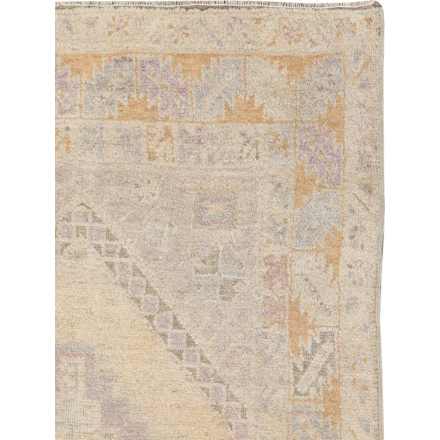 A vintage Turkish Anatolian rug. An overall soft palette dominates this rustic scatter with a soft beige hexagonal field...