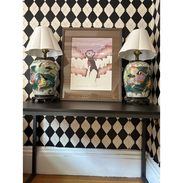 Large framed print by American artist Amado Maurilio Peña Jr., featuring a solitary Indigenous figure set against a...