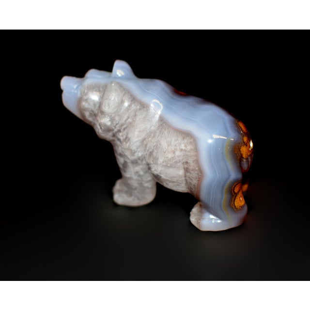 A beautiful hand-carved bear sculpture, crafted from natural agate, showcasing a soft interplay of smoky lavender, warm...