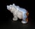A beautiful hand-carved bear sculpture, crafted from natural agate, showcasing a soft interplay of smoky lavender, warm...