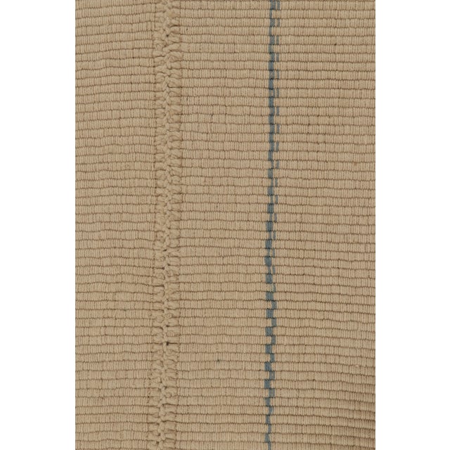 Handwoven in wool, this 6x9 Rez Kilim balances a warm neutral field with fine blue linear accents that lend rhythm and...