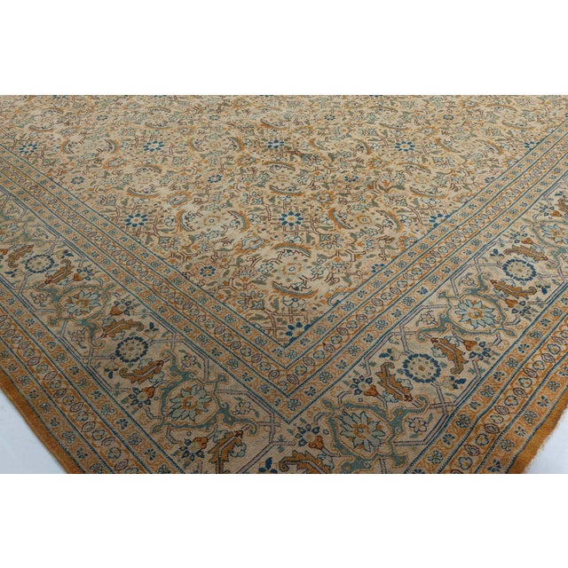 An early 20th century Persian Tabriz antique rug, the cream field with an overall herati pattern in light blue and gold...