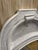 Elegant French Country arched wall mirror featuring top crest detailing and a distressed whitewashed finish over wood....