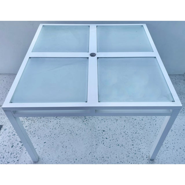 Geometric outdoor square dining table. Made of white aluminum with 4 frosted glasses that could be removed. Crate and...