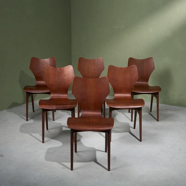 This set of six dining chairs features a solid teak frame with moulded plywood seats. The backs have a gentle wing shape,...