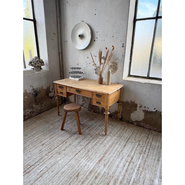Antique small desk from 1900 with a light walnut base and pine top and drawers. we love its compact size and the elegant...