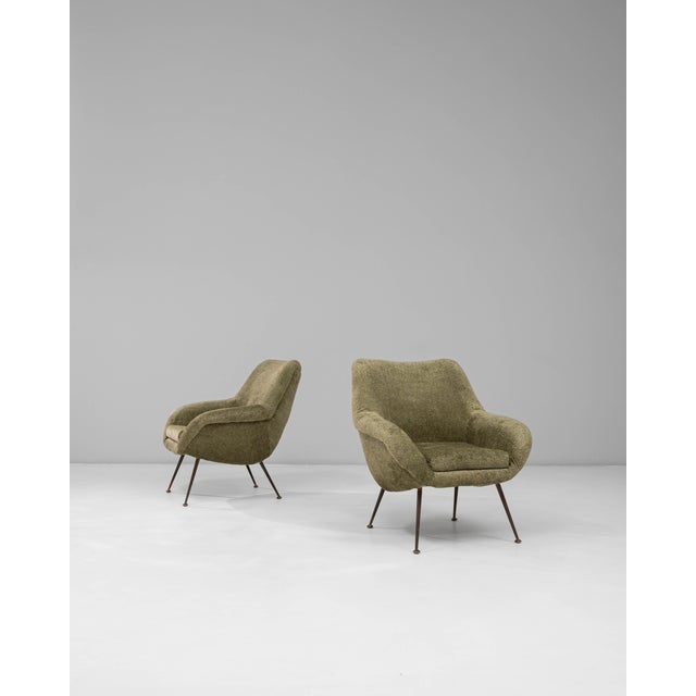 This pair of 1960s French green Art Deco upholstered armchairs features a sculptural silhouette that blends mid-century...