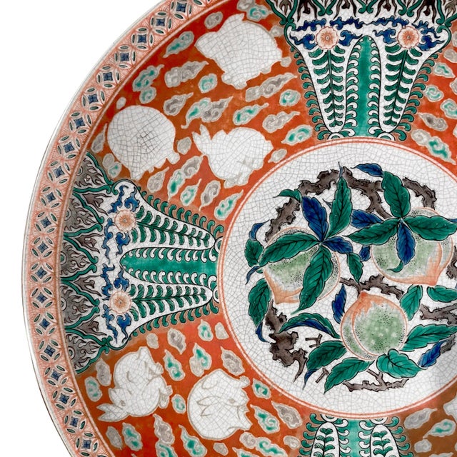 A Japanese Kutani charger from the Edo period. Central roundel of three peaches is surrounded by groups of rabbits and...