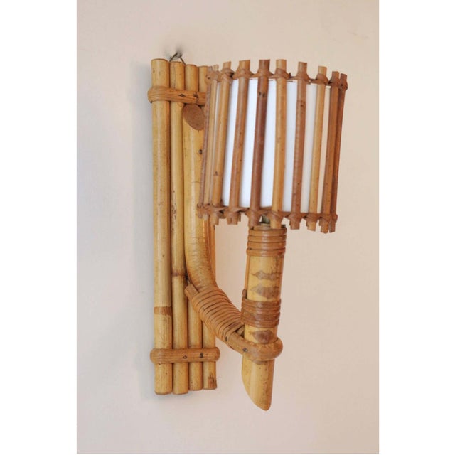 1950s, Louis Sognot pair of rattan sconces. Composed of a wall support formed of several bamboo rods assembled vertically...
