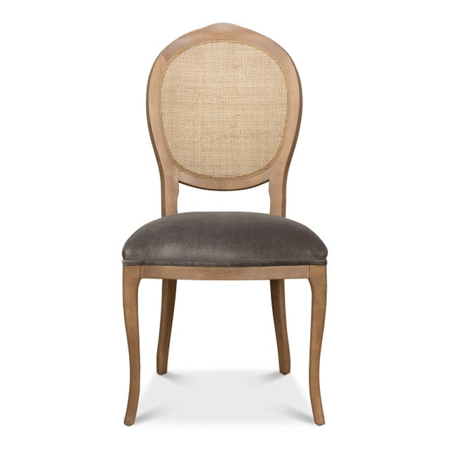 Natural cane stands out against a driftwood finish, with deep charcoal upholstery grounding the pale woven back. It is the...