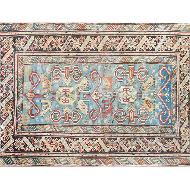 This early 20th-century Persian Shirvan rug is a masterclass in color, composition, and scale. Woven by Azerbaijani...