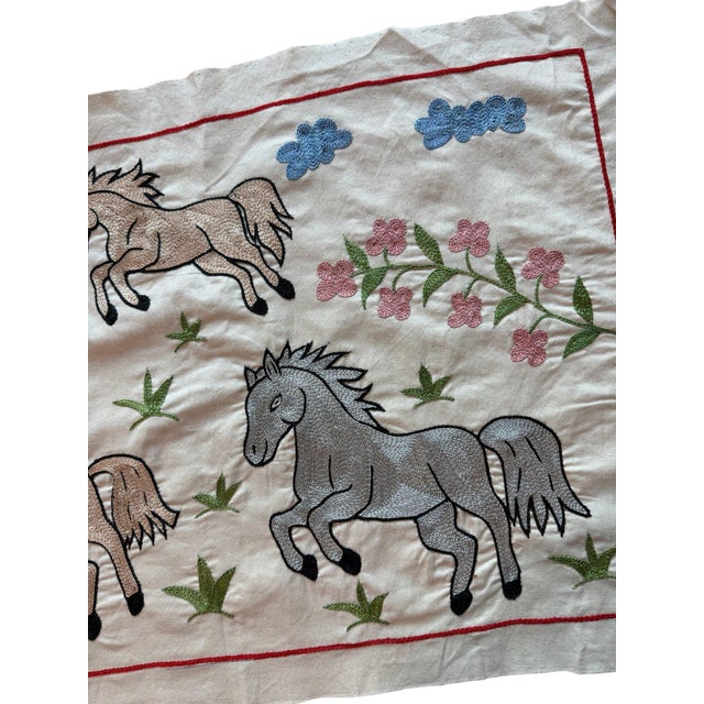 Hand-embroidered Suzani panel from Uzbekistan, worked in fine floss on a cream cotton ground. Six horses move across the...