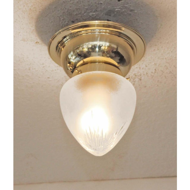 Art Deco ceiling lamp, circa 1920. Dish-shaped brass body. Original frosted glass shade with star cut. The lamp has been...