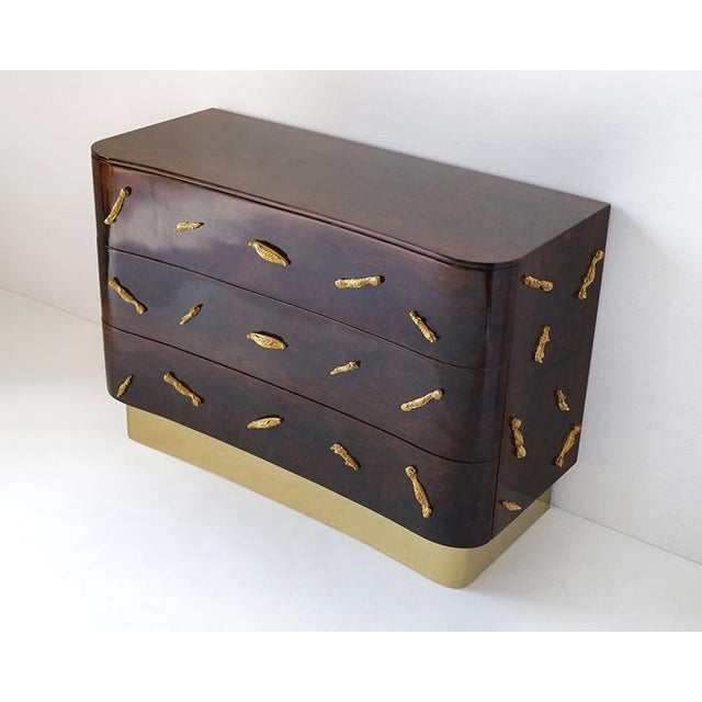 Dresser with three drawers, plywood structure, mahogany briar veneer, handles and decorative elements in golden brass,...