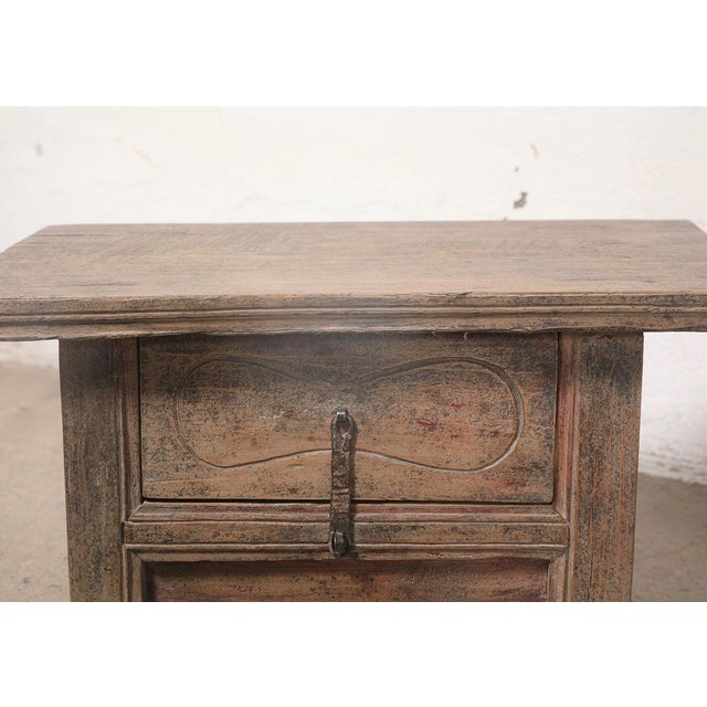 A charming vintage Chinese small cabinet crafted from solid elmwood, dating to the first half of the 20th century. The...