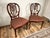 This handsome vintage pair of wheel back side chairs by Ardley Hall reflects the enduring appeal of classical English-...