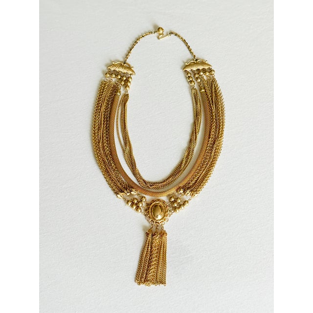 Vintage 1960s–1970s gold-tone statement bib necklace featuring multiple layered chain strands in varied link styles,...