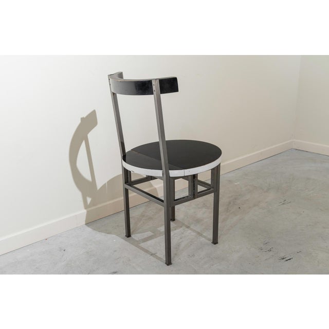 Folding chair made of metal and black and white lacquered wood. The seat lifts up and the iron frame folds, allowing for...