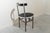 Folding chair made of metal and black and white lacquered wood. The seat lifts up and the iron frame folds, allowing for...