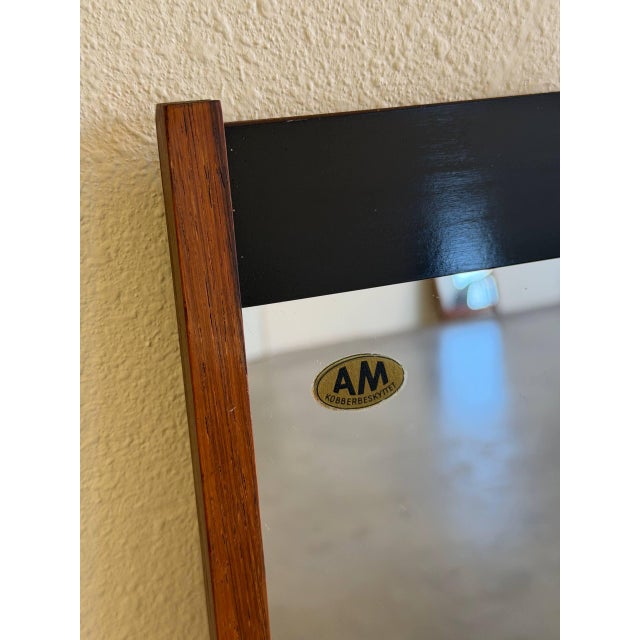 Authentic vintage wall mirror made in Denmark, featuring a slim teak frame with contrasting black accent details for a...