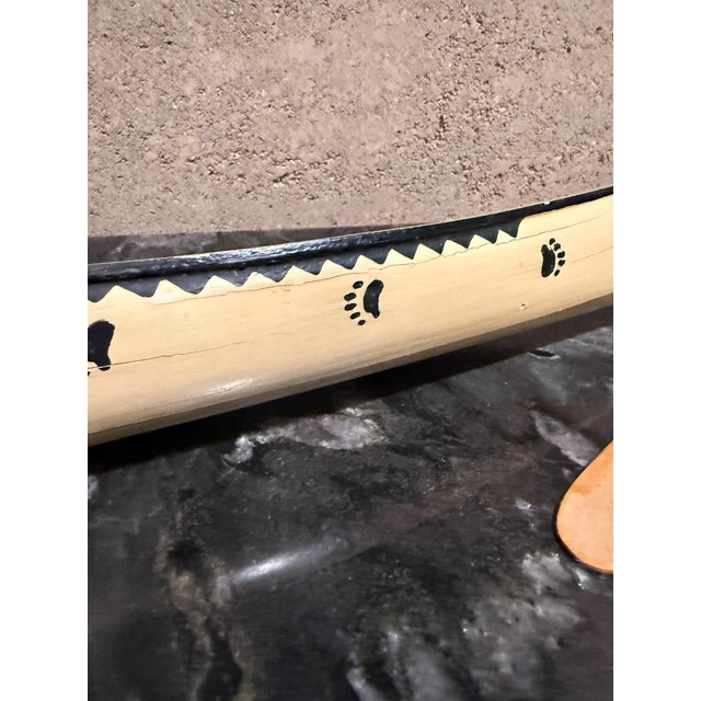 For your consideration, a vintage Native American handcrafted wooden miniature canoe and paddle, likely created as a...