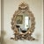 A mid-century solid brass mirrored wall sconce produced between 1955 and 1975, reflecting the neoclassical revival...