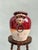A commanding terracotta vessel with sculptural lion-head handles, finished in rich red and cream crackle glaze. Evokes...