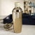 Notable for its glossy gold finish glass shaker that beautifully catches and reflects the light, this vessel gives a...