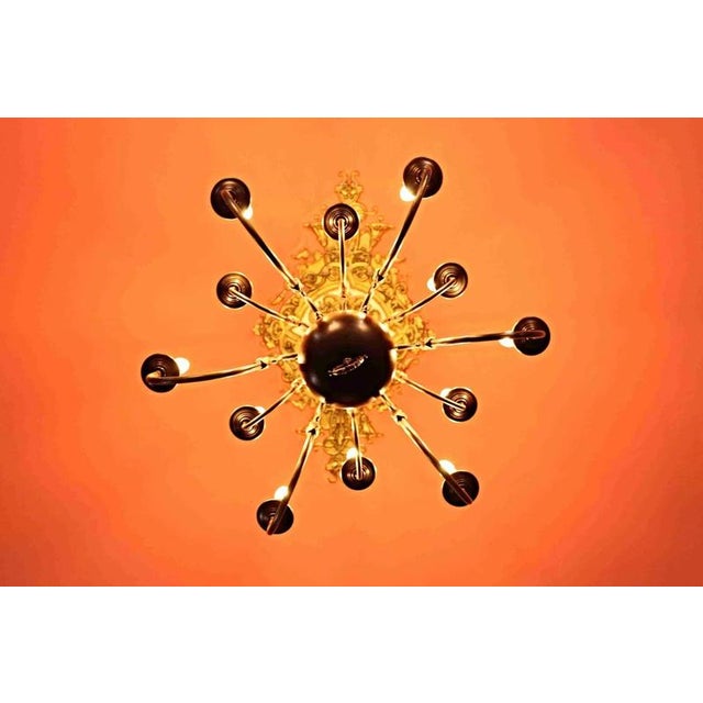 Twelve-arm chandelier made of patinated brass. For bulbs with a classic E14 candle thread up to 60W. The chandelier is...