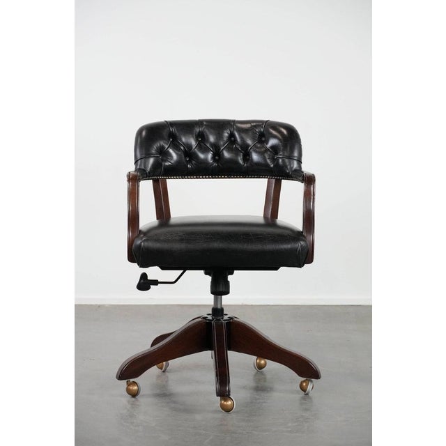 We offer this adjustable black, timeless Chesterfield office chair made of cowhide leather and wood on casters. This...
