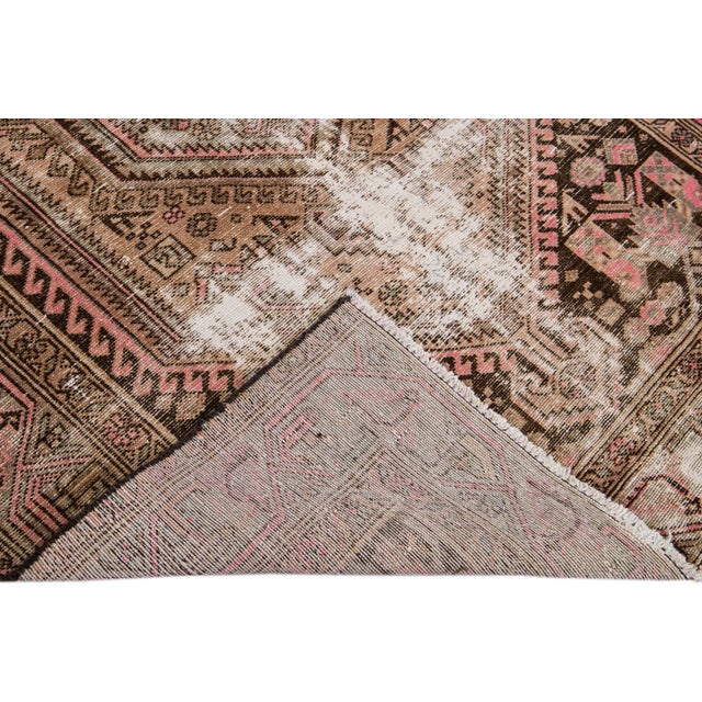 Beautiful Vintage Geometric hand-knotted wool rug with a peach field. This rug has pink and brown accents all-over a...