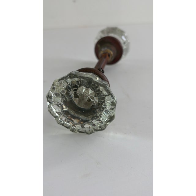 Antique clear pressed-glass door knob set with faceted glass knobs, metal rosettes and original spindle. Classic early...