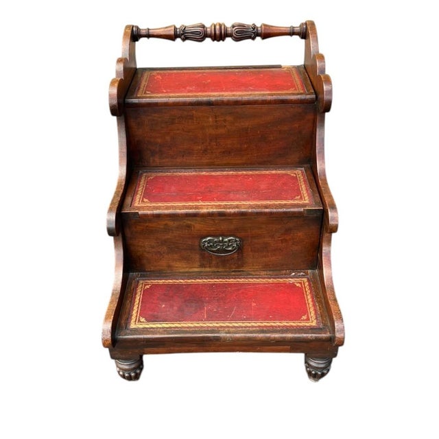 Antique steps concealing a commode. The steps are mahogany with red tooled leather treads. The center step pulls forward...