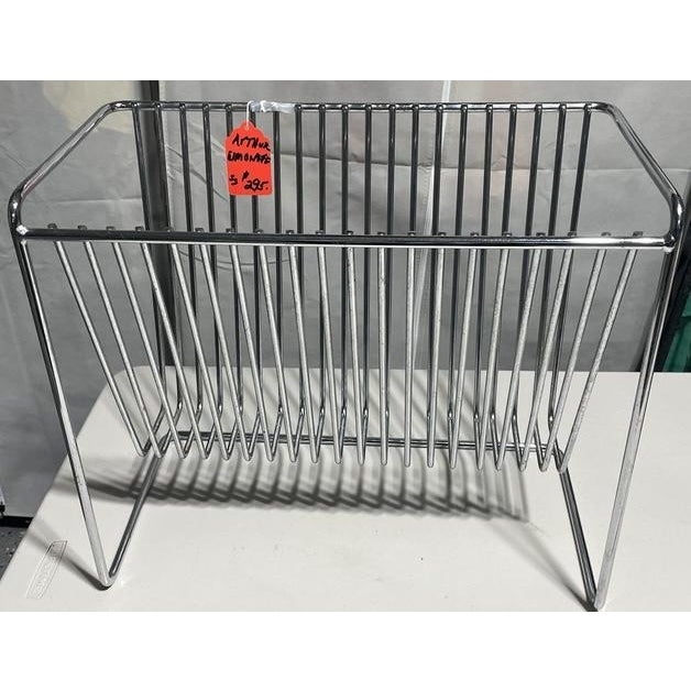A striking vintage magazine rack attributed to Arthur Umanoff, featuring a clean minimalist profile rendered in polished...