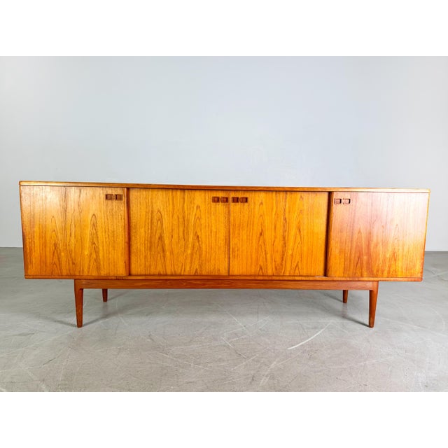 We offer a very nice and rare teak sideboard by Christian Linneberg for sale. The sideboard has four sliding doors and a...