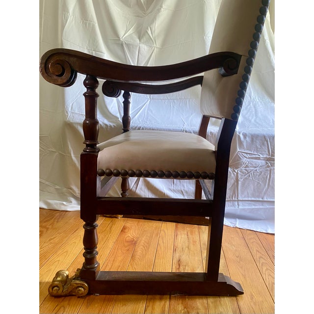 An original antique chair fit for a king. The high back and seat is covered in a light colored leather which should be...