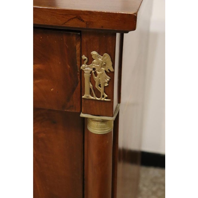 Antique Italian chest of drawers, originating from the early 19th century during the illustrious Empire period. A...