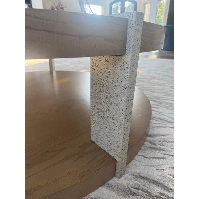 Serene circular solid wood cocktail table made of figured cathedral ash in the dune finish. The legs of this table are...