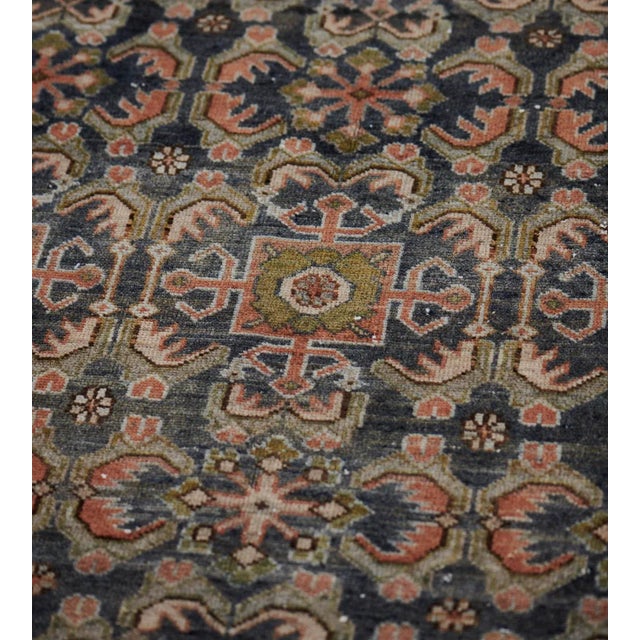 This antique Malayer rug has a shaded deep blue field with a dense angular palmette and serrated leaf vine around...