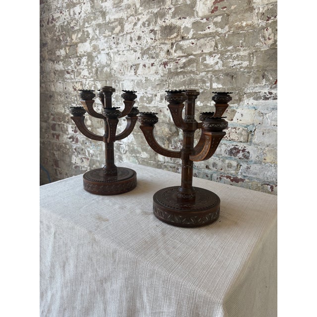 An exceptional pair of antique Eastlake-style wooden candelabras featuring richly carved geometric detailing throughout...
