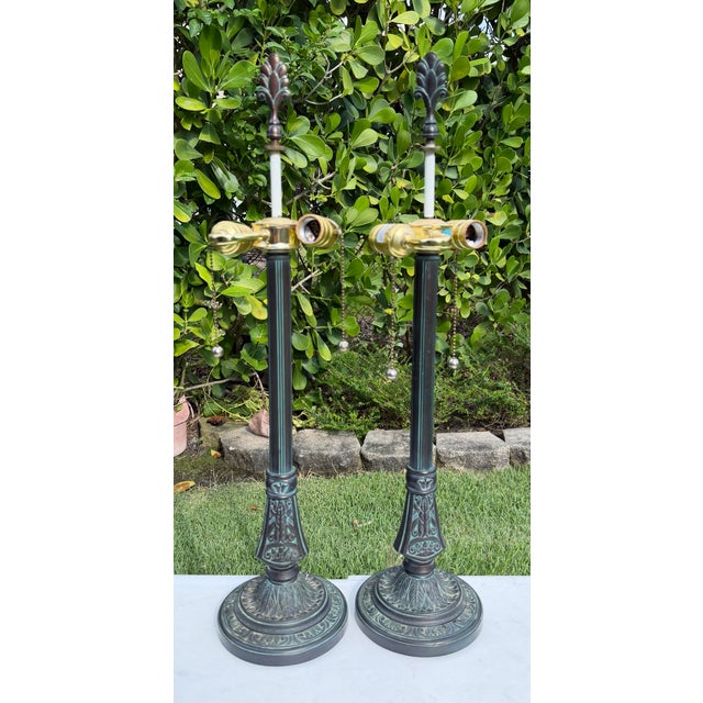 Striking vintage pair of Stiffel table lamps featuring tall architectural forms with elaborate neoclassical ornament....