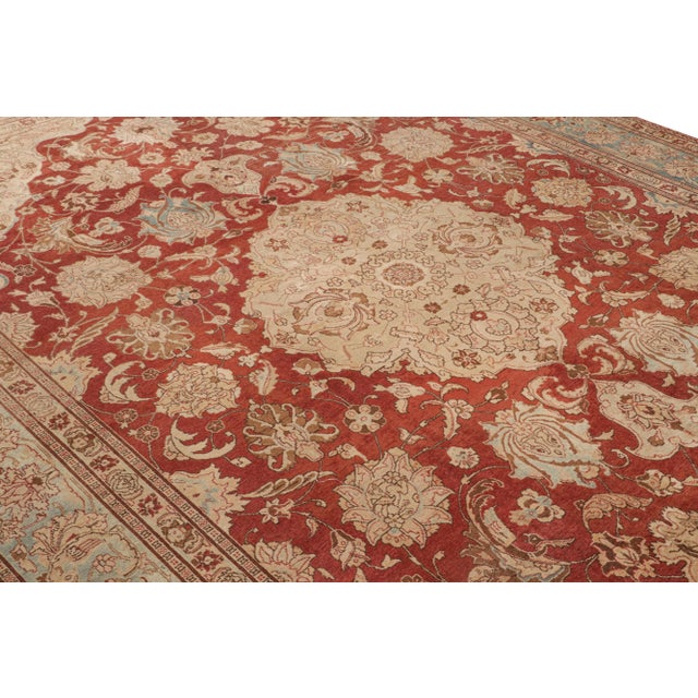 Hand-knotted in wool originating from Persia circa 1910-1920, this 10×14 antique rug connotes a Tabriz design in a...